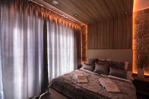 a bedroom with a large bed and a window at Apartment Luna Hrebienok in Vysoke Tatry - Stary Smokovec