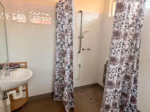 a bathroom with a shower curtain and a sink at Corrigin Windmill Motel in Corrigin
