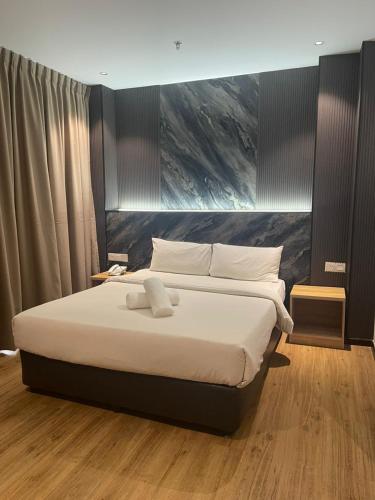 a bedroom with a large bed with white sheets at New Glow Hotel Miri Previously known as Citi Hotel in Miri