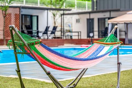 a hammock sitting in front of a pool at The Cliff Caravan Camping in Pocheon