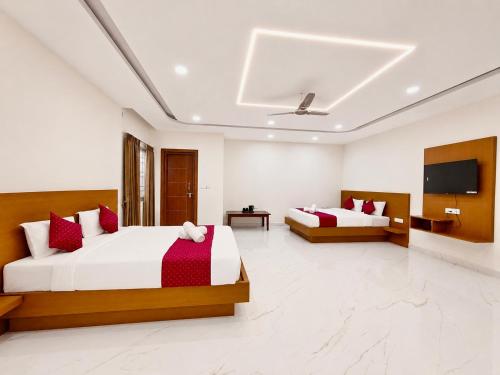 a bedroom with two beds and a flat screen tv at K V Comforts in Chikmagalūr