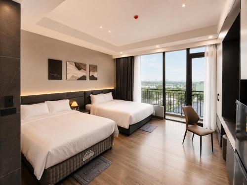 a hotel room with two beds and a balcony at Coline Hotel & Aparment in Ninh Binh