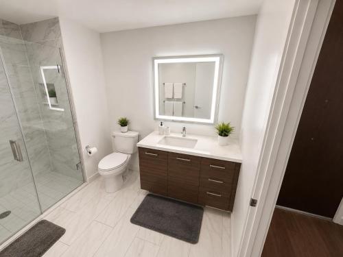 a bathroom with a toilet and a sink and a shower at Glendale Luxe Stays - Downtown in Glendale