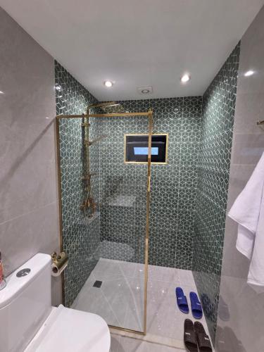 a bathroom with a shower with a toilet and a sink at A-frame-WHITE HOUSE-II in Qusar