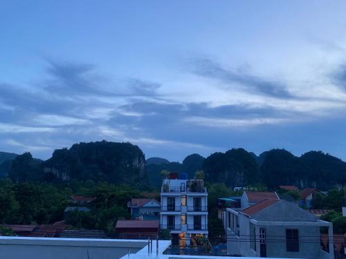 a white building with mountains in the background at Viet Anh Homestay in Ninh Binh
