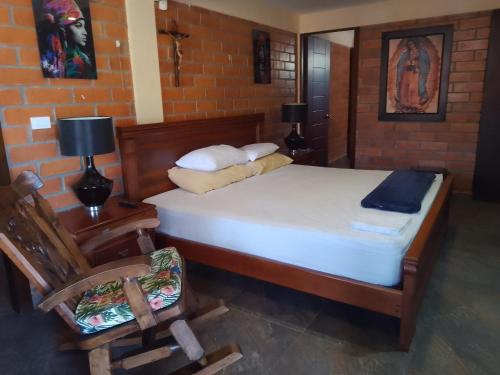 a bedroom with a bed with a chair and a chair at Villa Isabel in La Tebaida