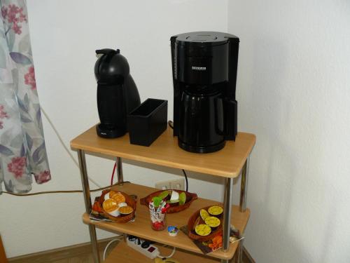 a coffee maker on a table with plates of food at Ferienwohnung Sauer in Wöhrden