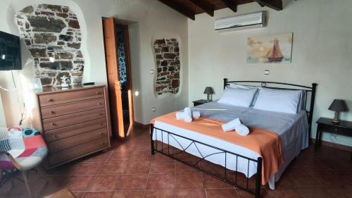 a bedroom with a bed and a chair in a room at Amelie's Stone House in Vathý