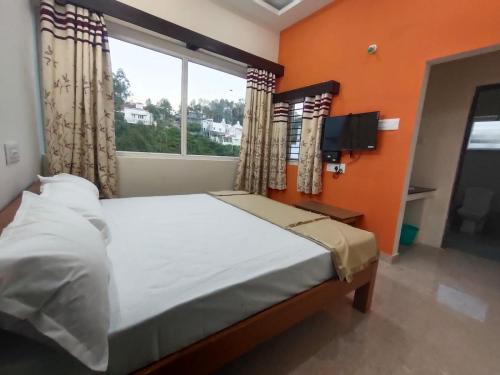 a bedroom with a large bed and a window at Grandwood Coco Resort Yercaud in Yercaud
