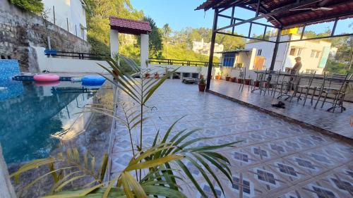 a swimming pool with a plant next to a building at Grandwood Coco Resort Yercaud in Yercaud