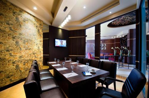 a dining room with a table and leather chairs at Tongtara Riverview Hotel in Bangkok