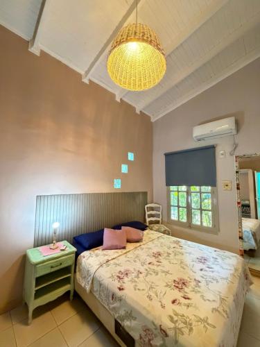 a bedroom with a bed and a table and a lamp at Casa amplia, cómoda en Cataratas con piscina compartida, parrilla, cochera, wifi in Puerto Iguazú