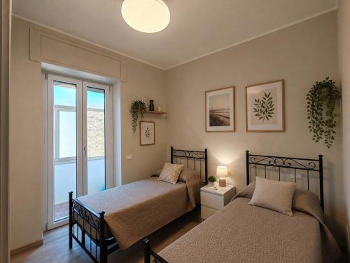 a bedroom with two beds and a window at Cozy apartment overlooking the main square in Orsogna