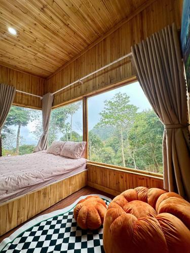 a bedroom with a bed and a window with a view at Dốc Mơ Homestay in Bản Bé