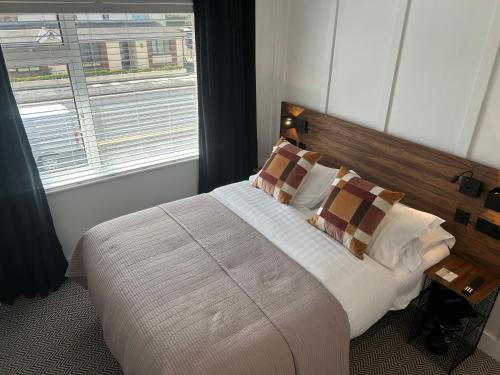 a bedroom with a large bed with a window at Bromielaw Room Only Accommodation in Seahouses