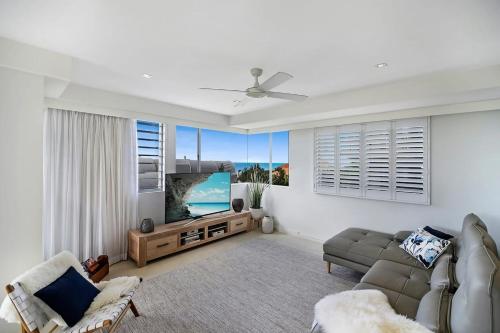 a living room with a couch and a television at Coastal Chic with Heated Pool Quiet Location in Sunshine Beach