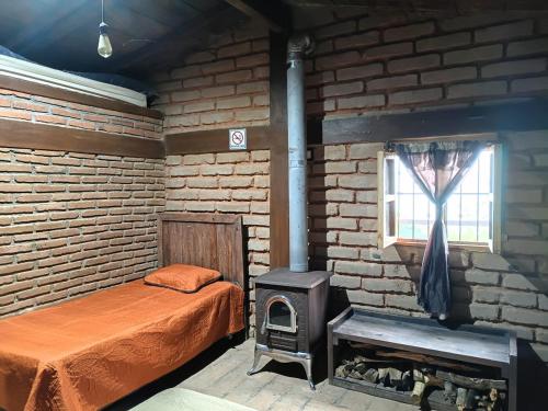 a bedroom with a bed and a wood stove at Cabaña El Fresno in La Petaca