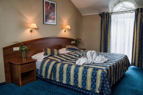 a hotel room with a bed with towels on it at Hotel Novum & Spa in Niepołomice