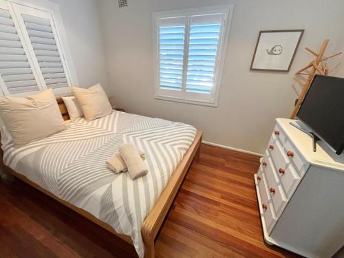a bedroom with a bed with two towels on it at Our Place in South West Rocks