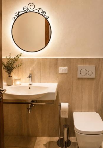 a bathroom with a sink and a toilet and a mirror at Residence MareVerde in Senigallia