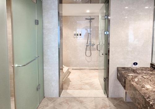 a shower with a glass door in a bathroom at Hotel Maremons in Sokcho