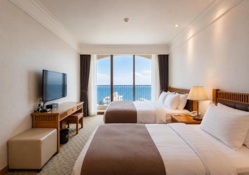 a hotel room with two beds and a large window at Hotel Maremons in Sokcho