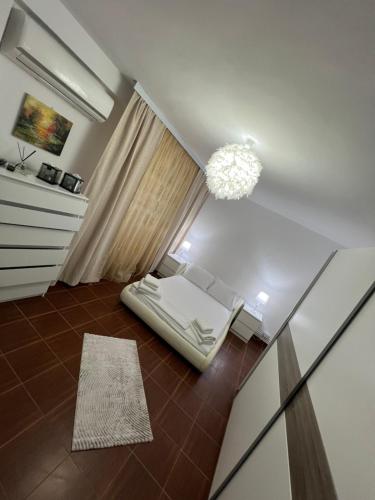 a living room with a bed and a chandelier at Studio Callatis Mangalia in Mangalia