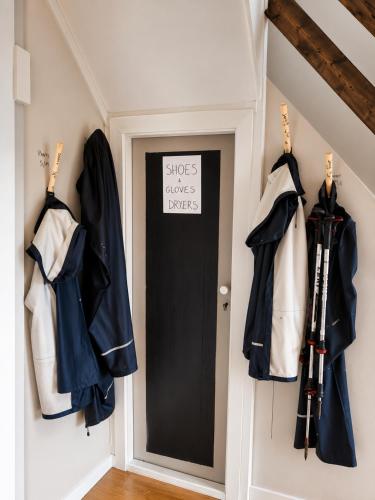 a door in a hallway with coats and umbrellas at Alfa Room - The LOWFO House Lofoten in Moskenes