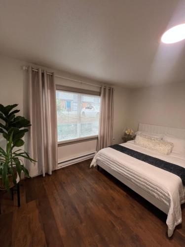 a bedroom with a bed and a large window at Alki Beach Nest in Seattle