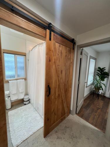 a bathroom with a wooden door and a toilet at Alki Beach Nest in Seattle