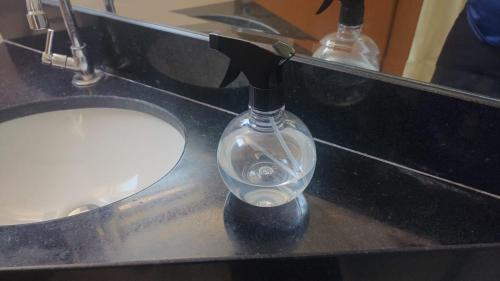 a glass bottle on a counter in a bathroom at Lagoa Flats com Super Varanda in Lagoa Santa