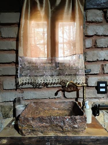 a window with a stone sink in a brick wall at Cabaña El Fresno in La Petaca