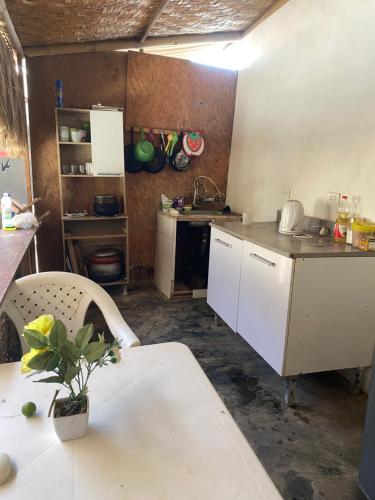 a kitchen with a table and a white counter top at Negritos Beach House in Negritos