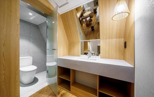 a bathroom with a sink and a toilet and a mirror at d hotel in Seoul