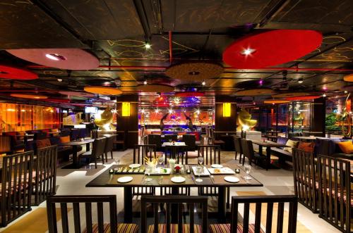 un restaurante con mesas y sillas y un bar en Tongtara Riverview Hotel, en Bangkok