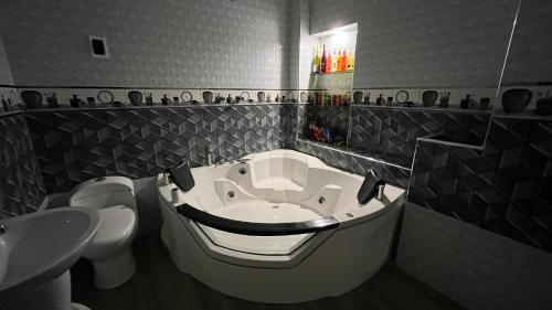 a bathroom with a tub with a sink and a toilet at El Refugio del Rey in Cajamarca