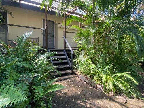 a building with stairs and plants in front of it at The Barracks Arcadia 1 in Arcadia