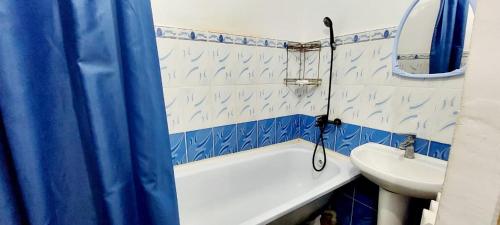 a bathroom with a white tub and a sink at ЖК Куралай in Qyzylorda