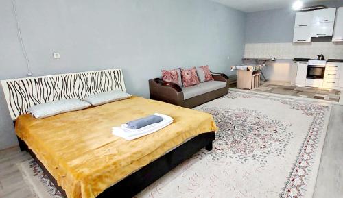 a bedroom with a large bed and a couch at ЖК Куралай in Qyzylorda