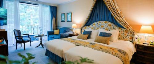 a bedroom with a large bed with a blue canopy at Hotel La Neige in Hakuba