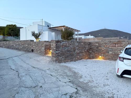 a stone wall with a car parked next to it at Maira's house in Agios Sostis