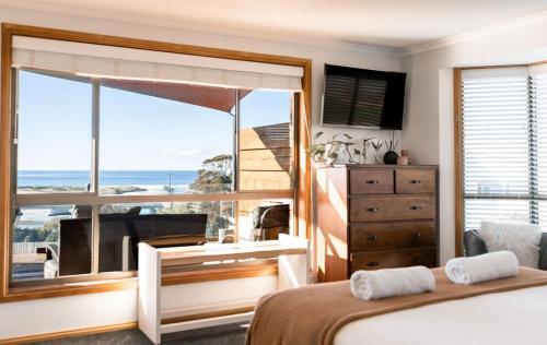 a bedroom with a large window with a view of the ocean at Drift - Watch the world go by in Scamander
