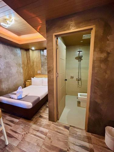 a room with a bed and a shower and a bathroom at Tagosilangan Beach House in Buruanga