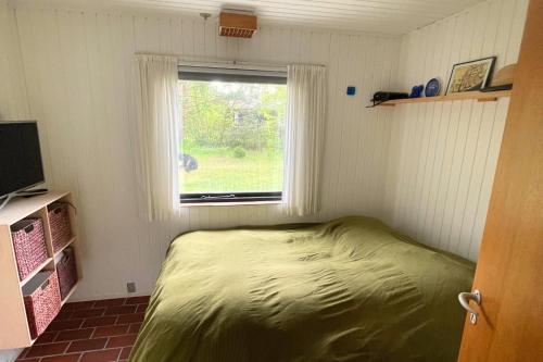 ein kleines Schlafzimmer mit einem Bett und einem Fenster in der Unterkunft Ferienhaus In Der Nähe Eines Schönen Sandstrandes in Gedser