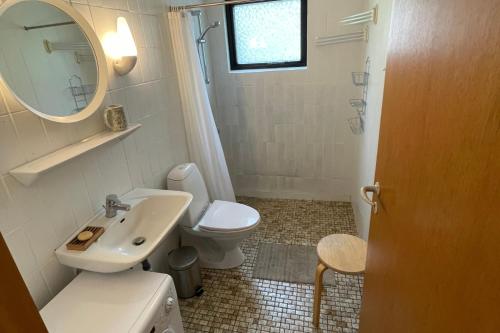 ein Badezimmer mit Waschbecken, Toilette und Spiegel in der Unterkunft Ferienhaus In Der Nähe Eines Schönen Sandstrandes in Gedser