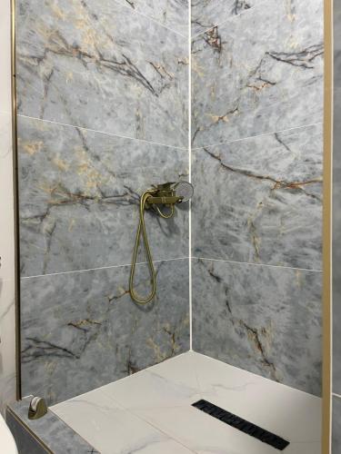 a bathroom with a shower with a marble wall at Moto Guest House in Kochkorka