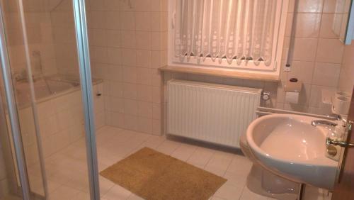 a bathroom with a shower and a sink and a tub at Ferienwohnung Bigi in Efringen-Kirchen