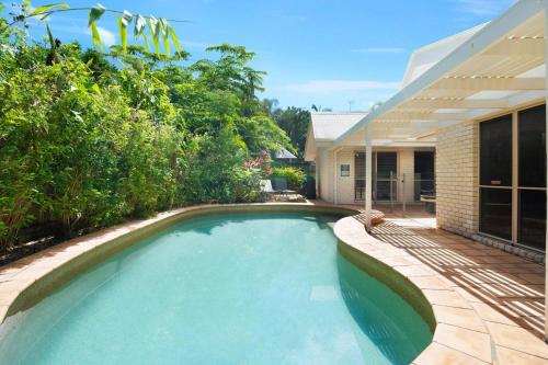a swimming pool in front of a house at Witta Circle 24 in Noosa Heads