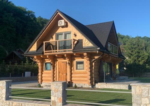 a log cabin with a black roof at Bałtowska Osada in Bałtów