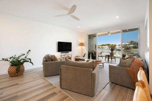 a living room with couches and a flat screen tv at Townhouse 6 Sunseeker Close 26 in Noosaville